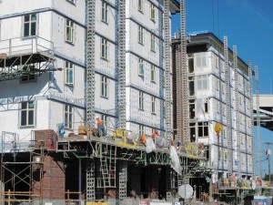 A continuous air barrier is installed with mechanical fasteners over gypsum board sheathing at the Ramona Apartments in Portland. Building wraps are the most cost-effective air barriers for framed wall construction. The air barrier on this project is vapor permeable to allow diffusion drying.