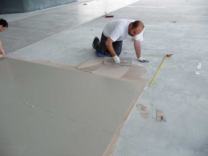 In the photo above, large-format thin tile being installed over concrete.