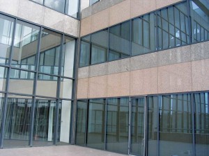 Rain that impinges on the curtain wall above the exterior door has to flow down over the threshold, then turn and drain across the low-slope walking surface.