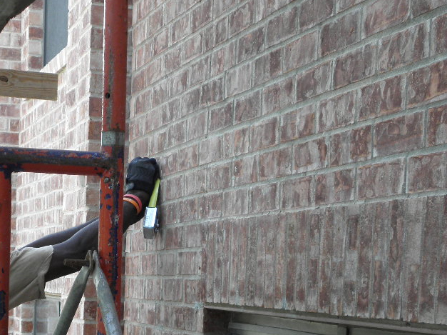 B) Remedial anchor spacing is measured and marked on the face of the masonry.