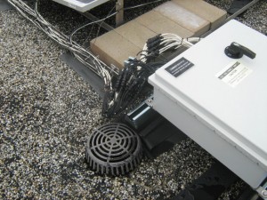 Ballasted, non-penetrating PV system and wiring located near a roof drain.