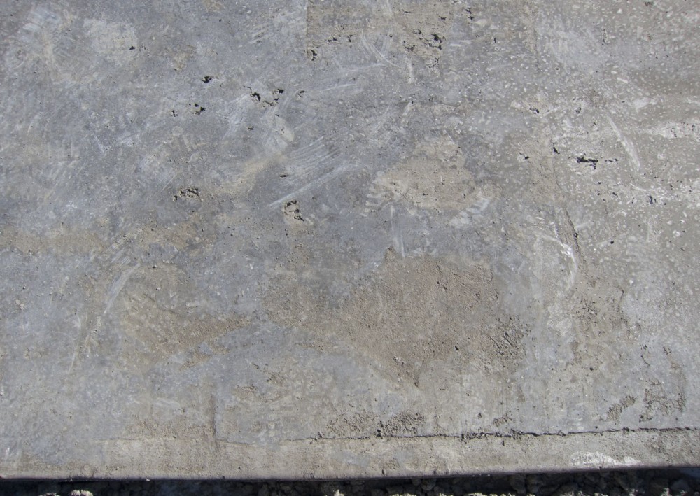 Finishers refer to this as ‘losing the slab.’ Hot conditions speed up the set-time of the cement, and moisture loss deprives the finisher of enough fluid cement paste to cover the interstices between the coarse aggregate (‘closing’ the surface). The result is a porous, rough slab with many surface defects.