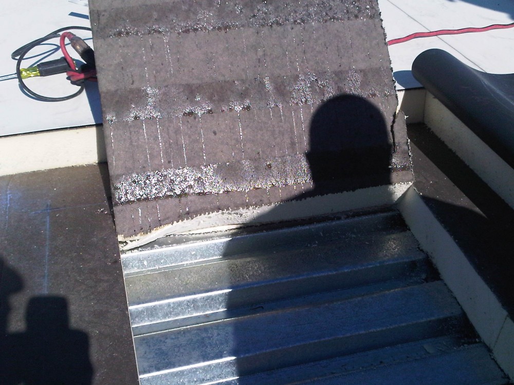 Condensation forming on the bottom of the insulation of a white roofing assembly in a northern climate.