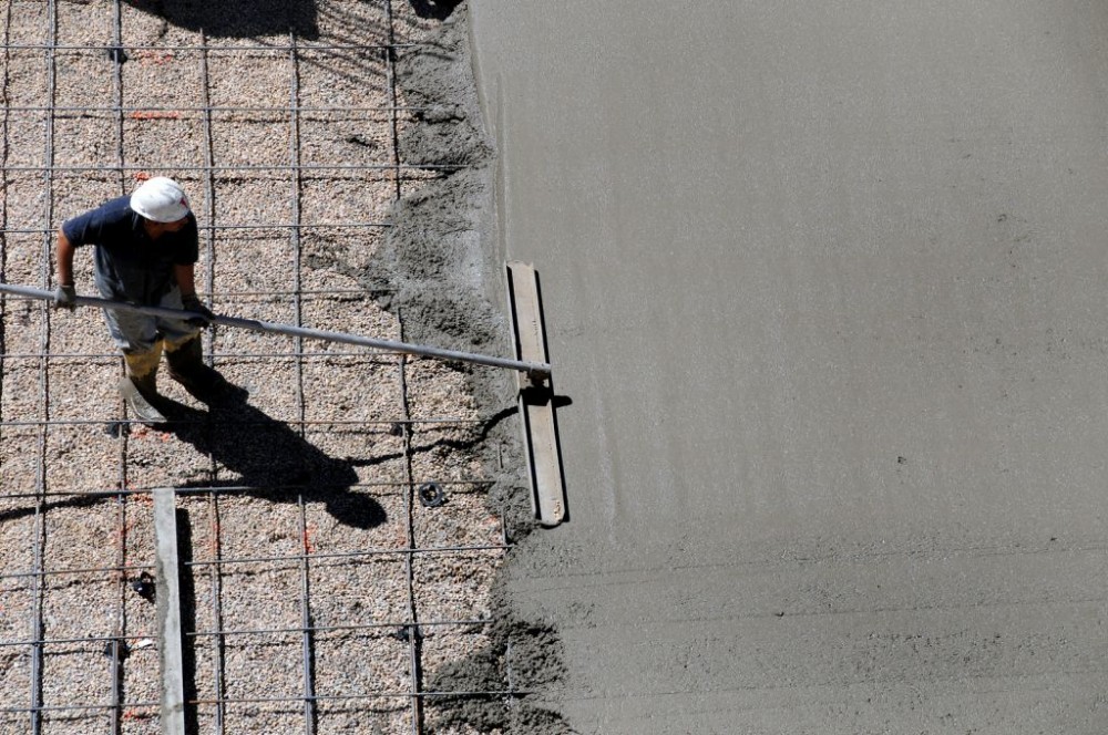 A concrete worker is smoothing wet cement for the foundation of a new commercial building. The American Concrete Institute (ACI) has ramped up its educational offerings. Photo © BigStockPhoto/Chris Anton