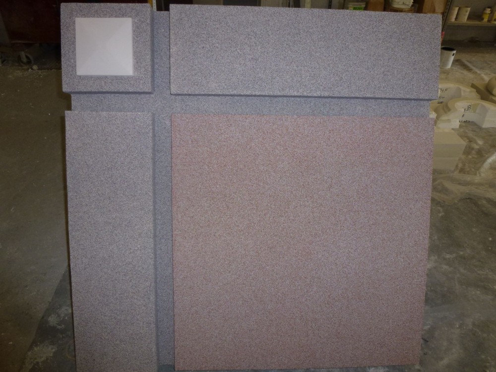 Two different EIFS finishes are displayed here. The small medallion in the left corner shows a smooth finish to replicate limestone. The finish in the rest of the sample is shown in gray and and a contrasting red color. This finish consists of a ceramic bead in a clear acrylic binder for abuse resistant interior and exterior applications. Photo courtesy Southern Stucco