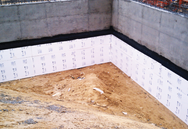 A layer of foam insulation helps protect the water proofing on foundation walls during backfill.