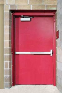 Red steel door set in masonry walls.