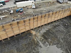 Perimeter groundwater collection trench at bedrock-alluvium interface leading to filtered portable sump well.