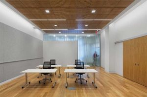 A furnished multipurpose room supporting group training in the Staten Island Family Justice Center quickly resets as a conference room, presentation venue, or event space by using tables on casters and stacking chairs.