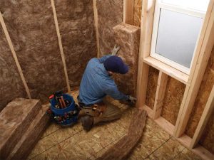 Fiberglass batt installation in the interior cavity—shown in the above photo between the wood framing—is a relatively non-labor-intensive process and effective against acoustical and fire protection.