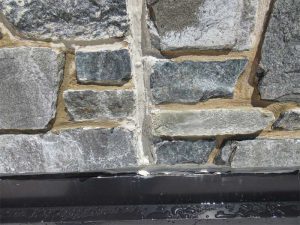 The wall panels at areas of leakage relied on the secondary seal at the face of the stone veneer to prevent water from entering the building. Water bypassed the secondary seal and entered the building due to the lack of a primary seal at architectural precast concrete (APC) panel joints. Photo © Jeffrey N. Sutterlin, PE