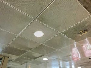 These painted metal ceiling panels can be rejuvenated by wiping with a degreasing cleaning agent. However, the non-woven acoustic fabric behind the perforations may have to be replaced since grime attached to the fabric is more difficult to remove and may also interfere with noise reduction. Photos courtesy Ceilume