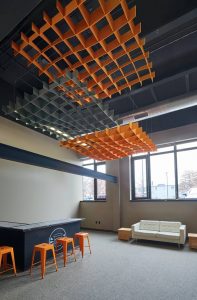 Three 2.4 x 2.4-m (8 x 8-ft) open cell felt clouds were installed to reduce reverberation time and provide spot acoustics over the student-run coffee bar at Stone Independent School. The clouds are installed in layers to obtain more acoustical performance.