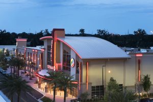 Designed by architects with the RLS Design Group, the sweeping metal roof over the entrance at Regal Cinemas in Gainesville, Florida, helps it stand out among the surrounding stores and restaurants. Photo courtesy hortonphotoinc.com