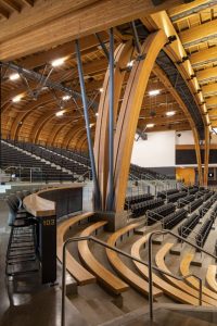 In the arena, thoughtfully designed 3D timber/steel trusses, meticulously proportioned, extend over a length of (45.7 m) 150 ft, reaching a distinctive timber portal frame arch that gracefully delineates the intimate space within the arena.