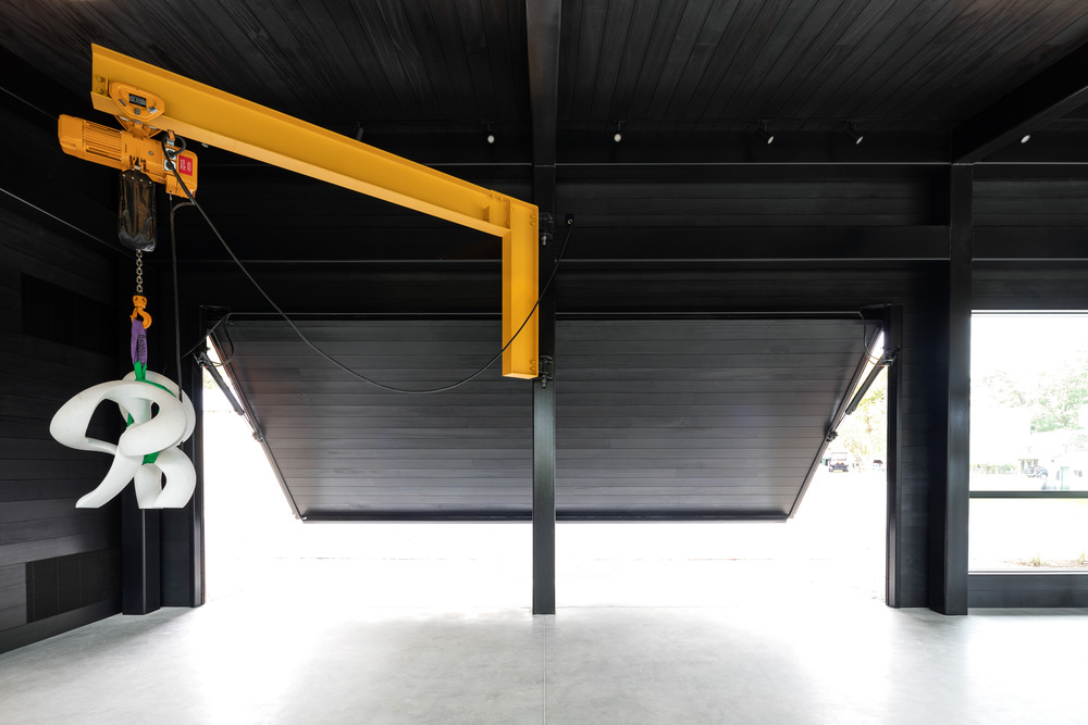 A hydraulic loading door with a flush threshold provides rolling access to the main studio space. Inside the door, a jib crane aids in the installation and removal of large-scale sculptures.