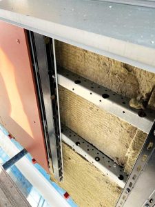 A fiber cement panel overcladding system with insulation supported by a light-gauge metal subframe cantilevered from the backup, designed to address dead load, wind load, seismic concerns, thermal expansion and contraction, and deflection for varying backup conditions.