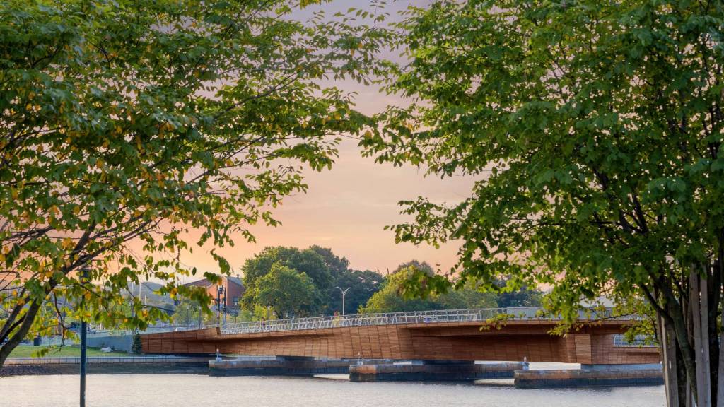 Photo showing the curvature of the bridge's form. The bridge's overall structure is metal over which curved timber slats were overlaid.