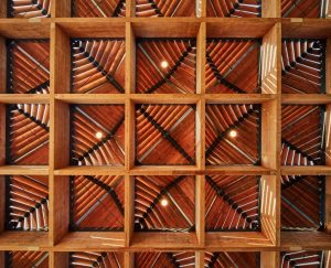 The underside of the timber canopy, showing the patterned, louvered roofscape.