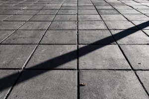 Symmetrical concrete floor tiles in a grid pattern.