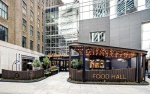 The atrium at High Street Place, Boston, was transformed into a food hall featuring a central gathering area with bars, restaurants, and seating.