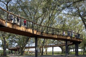 A pedestrian bridge winds through the park.