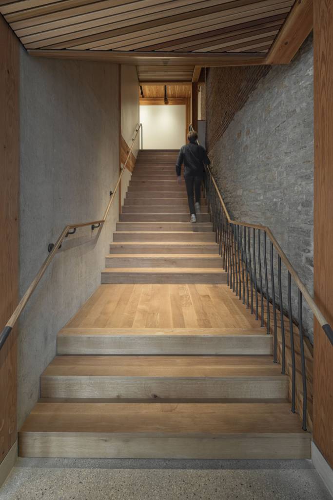 A wooden staircase leads to the upper-level floor.