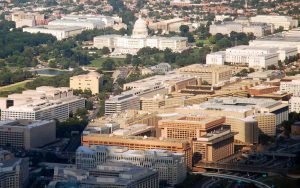 An aerial view of the capital city, showing similar-scaled buildings exhibiting historical architectural styles dominated by masonry and concrete forms.