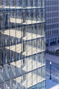 The transparency of the facade that lets natural light in. The photo also shows the recessed columns and tapered ceilings.