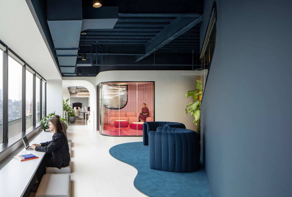 A pink tech-less enclosed meeting space hidden behind a mirrored door, a dark and moody open nook, and a work counter sunken into the floor.