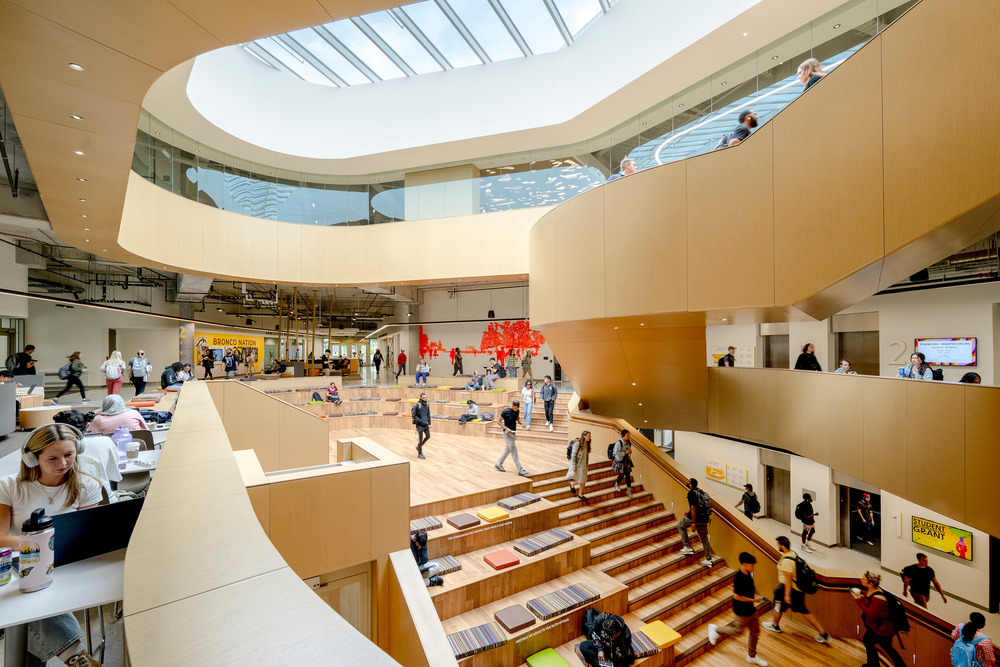 Shown here is the atrium in the center of the student center. Stairs lead students to an auditorium, which is lit from natural light by a large skylight above.