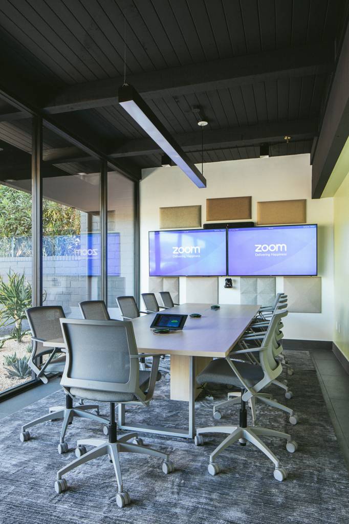 Meeting room, naturally lit from a floor-to-ceiling window with a view to the outside.