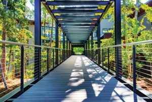 Here a cable railing is installed on a covered bridge in a garden setting, which allows the bridge to be lit up with natural light.