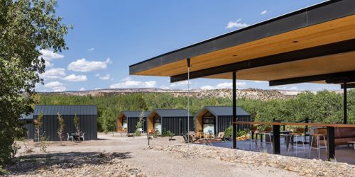 Rural resort with modern cabins and outdoor seating under a broad overhang.