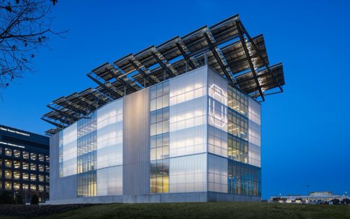 lit up building with energy panels on the roof