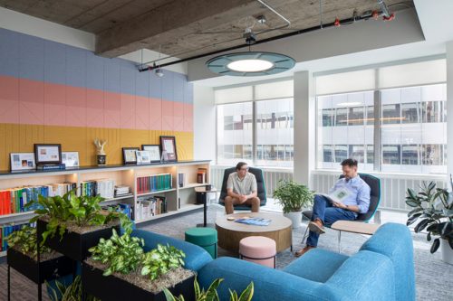 rendering of a new colorful office space's lobby designed like a lounge with two employees chatting