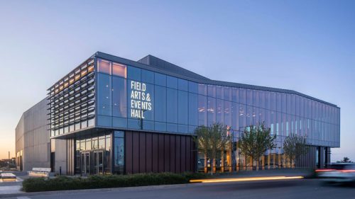 Glass-clad low-rise building with 'Field Arts & Events Hall' written on one side 