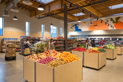 supermarket's veggie section with customers looking at produce