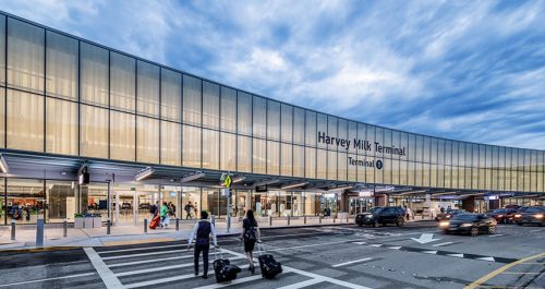 new airport terminal with passengers and cabin crew around the entrance