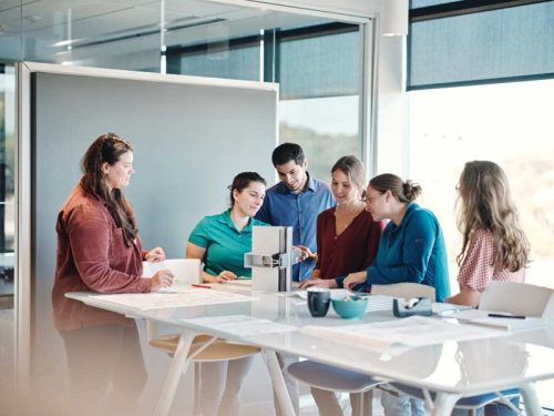 group of people in an office board room, discussing and collaborating