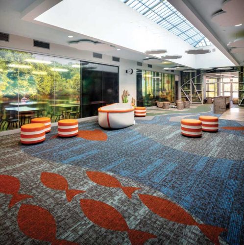 empty area with orange circular seating and fish pattern on the carpet