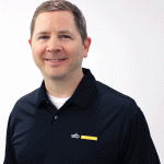 David Hohenstern with short brown hair and a friendly smile is facing the camera. He is wearing a dark blue polo shirt with the logo "sto" and a yellow strip on the left side. The background is plain white.