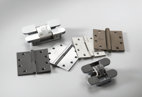 The image shows an assortment of metal hinges laid out on a light gray background. The hinges vary in color, including silver, gray, white, and bronze. Each hinge has a distinctive design, with some featuring rounded edges and others having a more angular appearance. The surface of the hinges is reflective, highlighting their metallic finish.