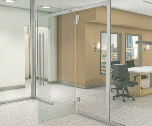 A transparent glass door opens into a contemporary office space. The room features large windows with views of a city skyline, a long wooden desk, and ergonomic chairs. The walls are painted in a warm beige tone, and there are overhead lights illuminating the area.